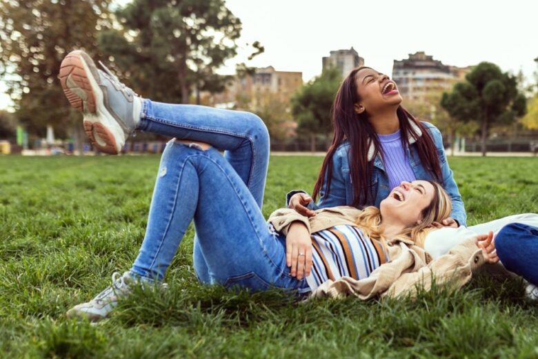 girls sat on grass, laughing